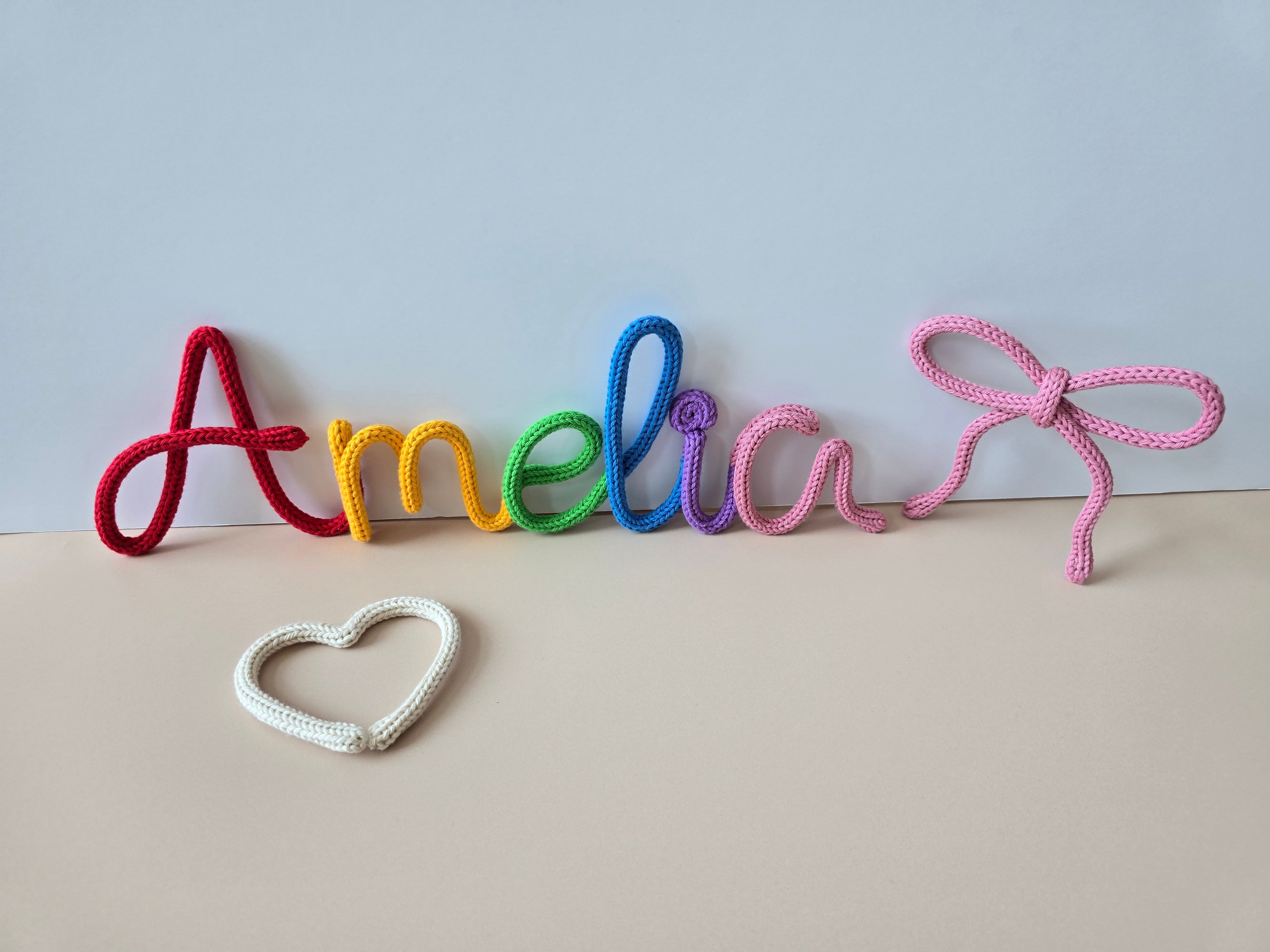 personalised knitted wire name Amelia with a heart and bow on a light background