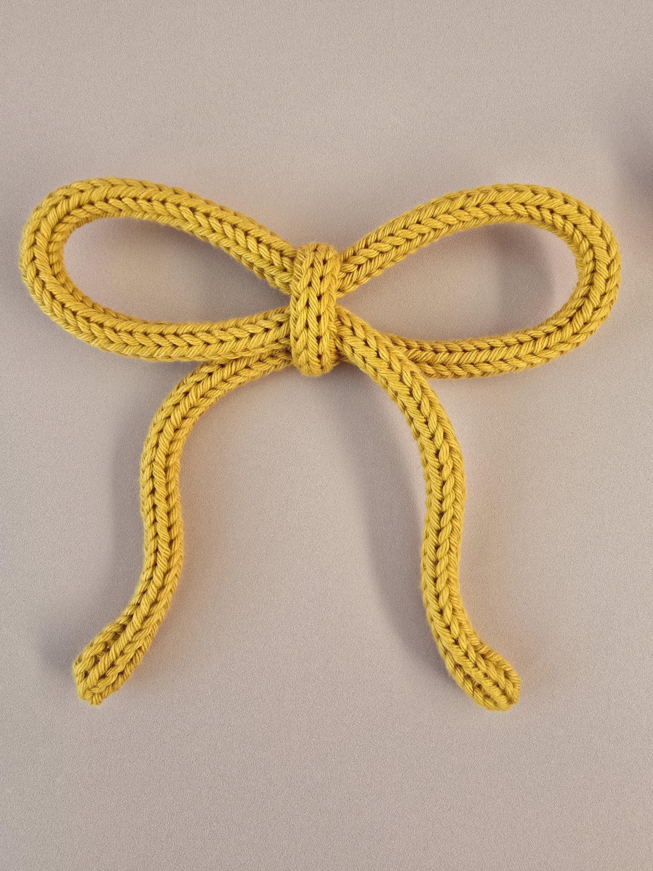 Handmade cotton yarn bow decorations in soft pastel and neutral colours
