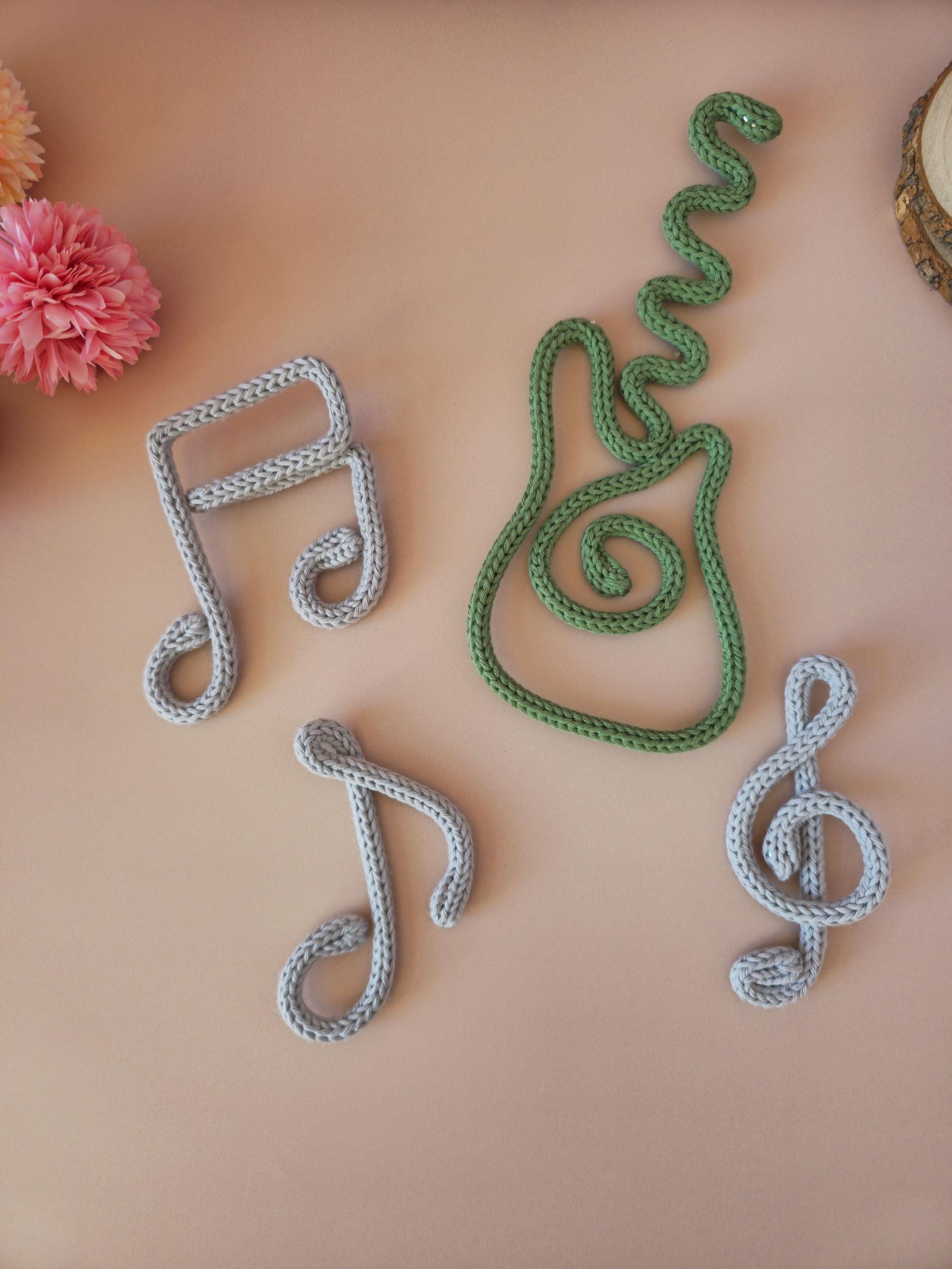 Decorative items shaped like musical notes on a pink background with flowers.