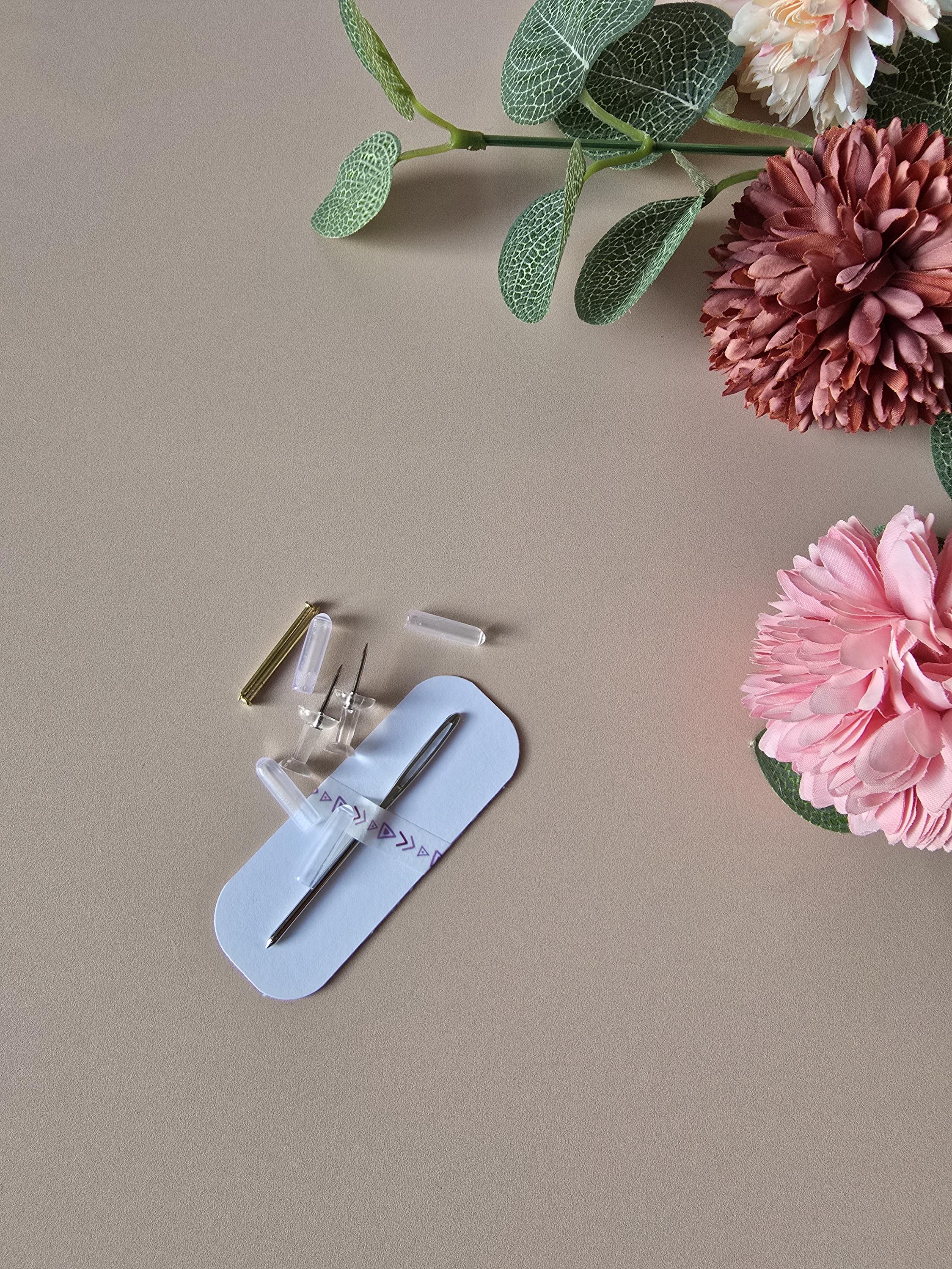 Small tool set on a beige surface with pink and green flowers.
