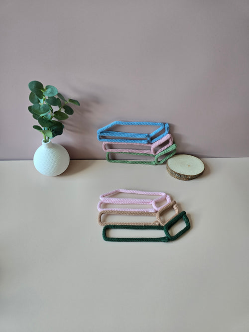 Knitted wire book stack wall decor in blue, pink and green