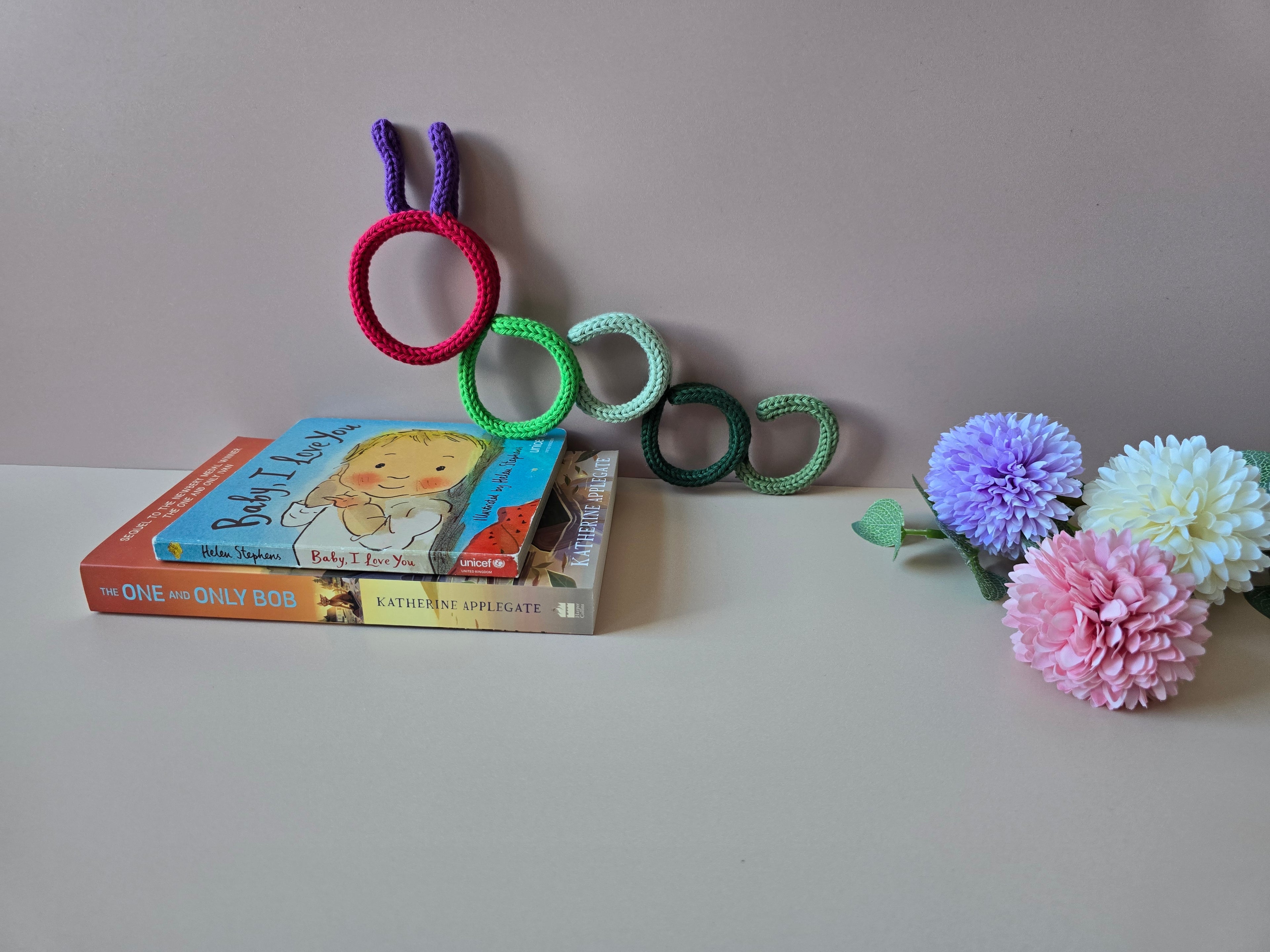 Handmade bookworm decoration displayed with books as a book lover gift