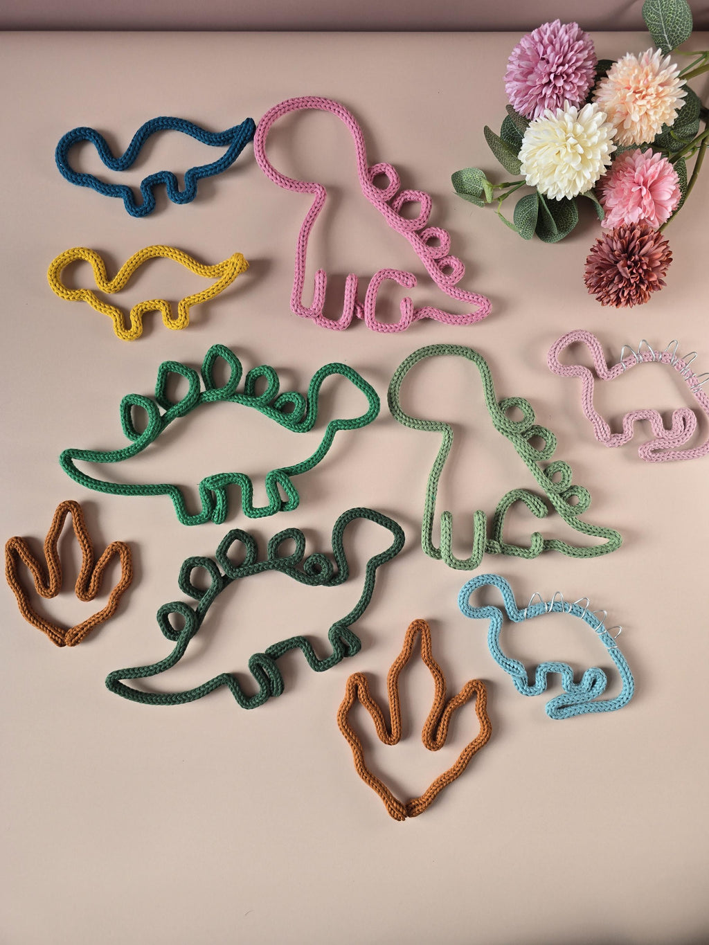 Knitted wire dinosaur wall decor shown in different styles and colours