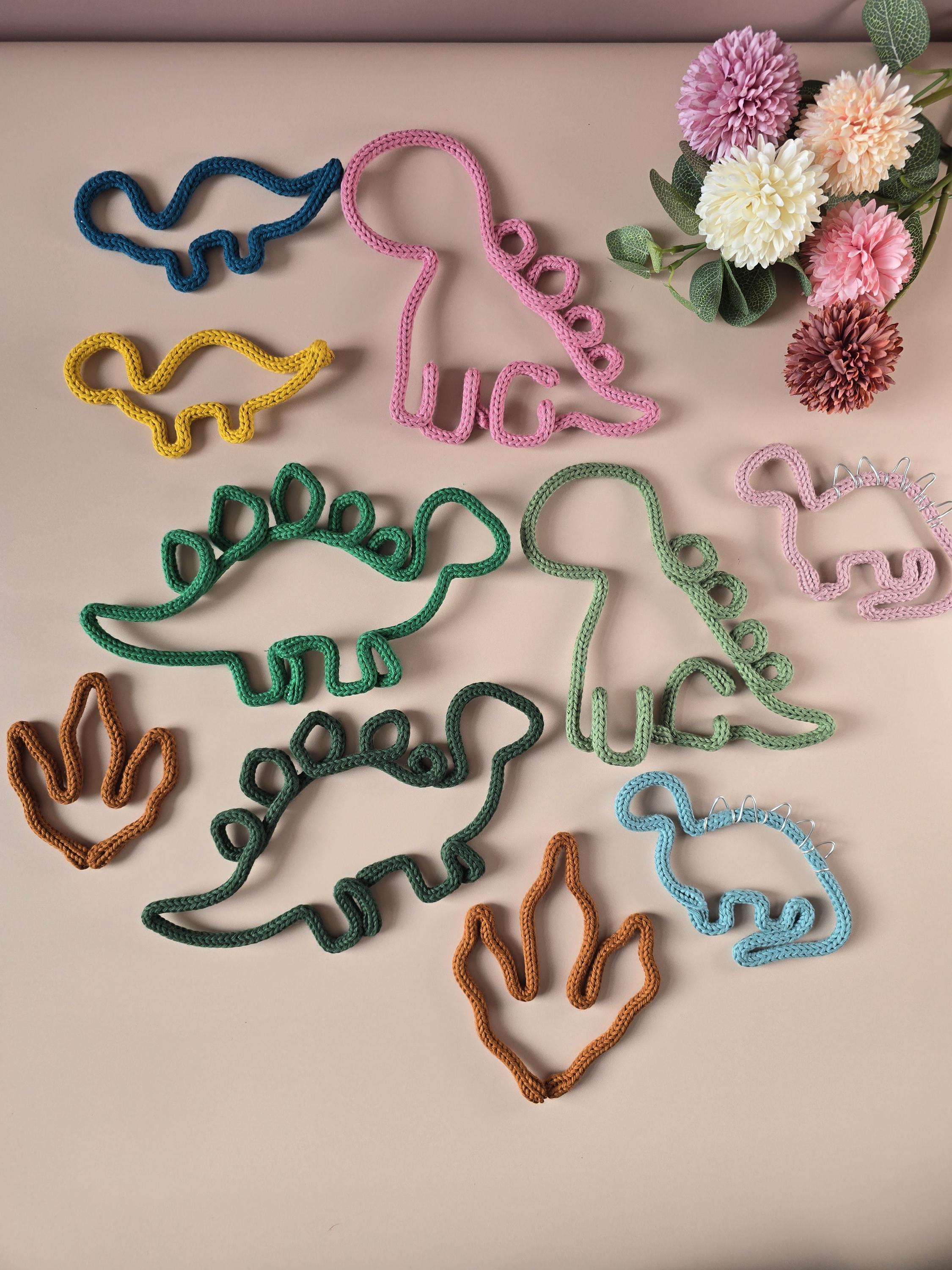 Knitted wire dinosaur wall decor shown in different styles and colours