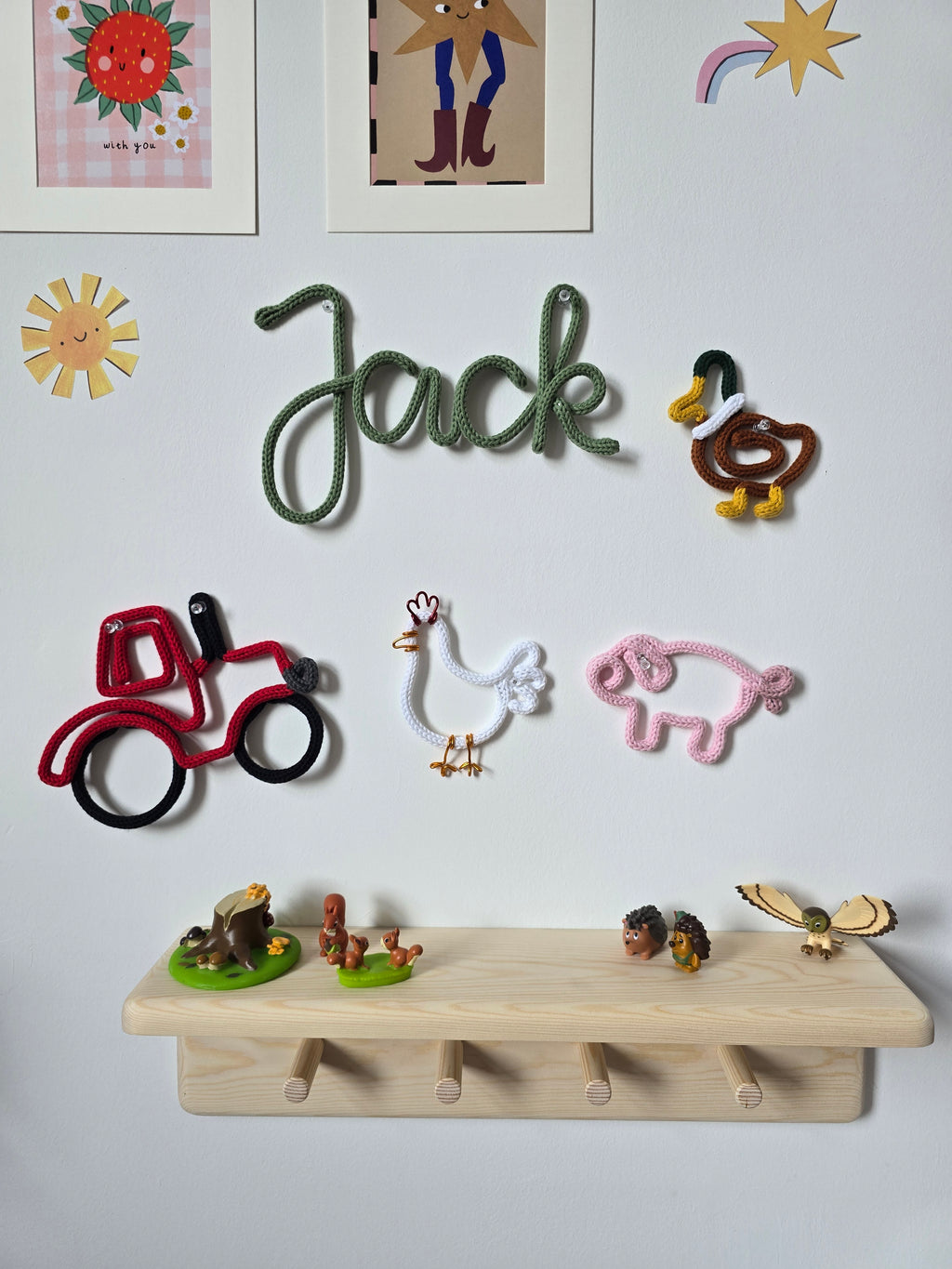 Farmyard knitted wire wall décor collection with a tractor, duck, chicken and pig in a child’s room.