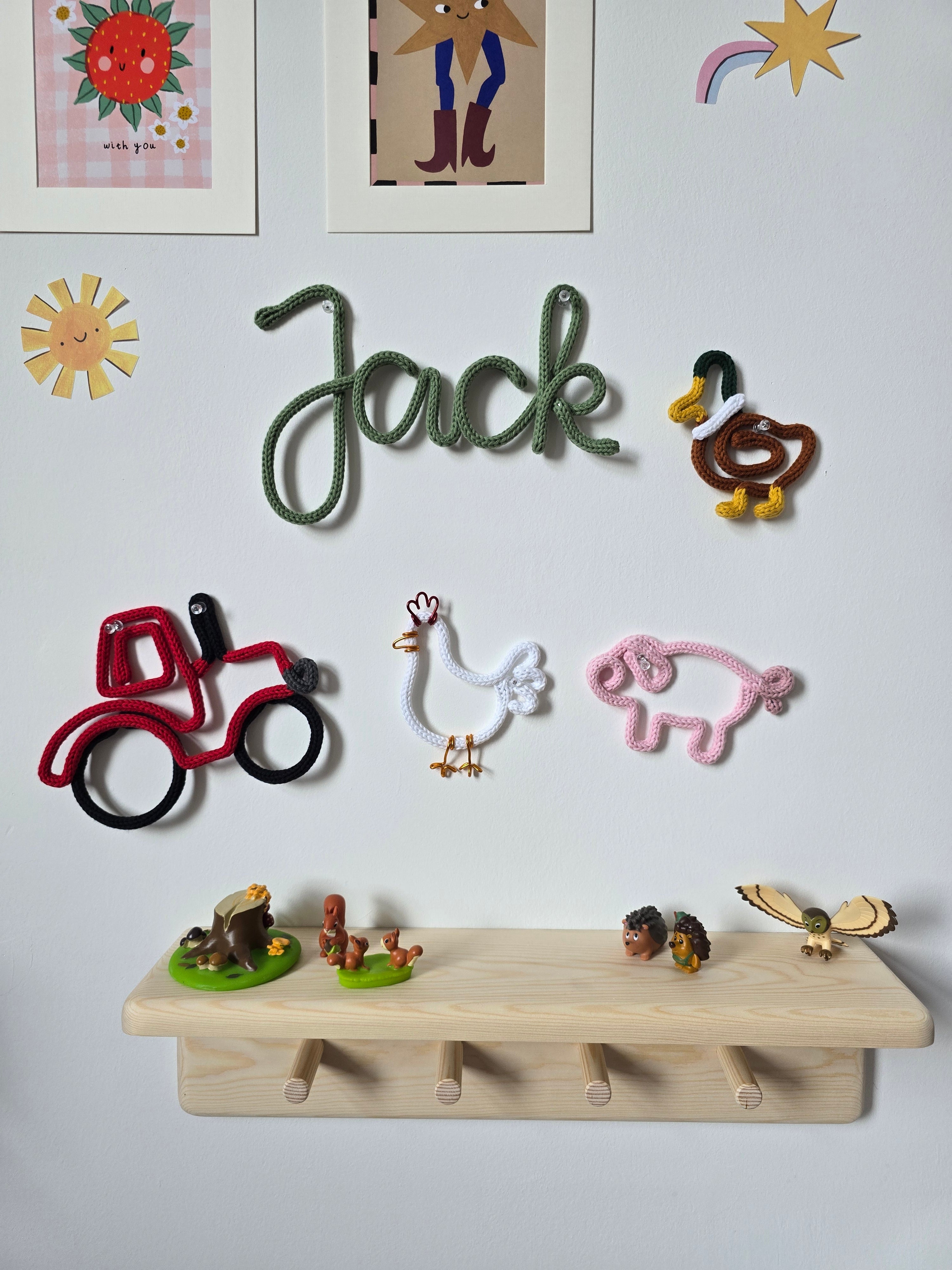 Farmyard knitted wire wall décor collection with a tractor, duck, chicken and pig in a child’s room.