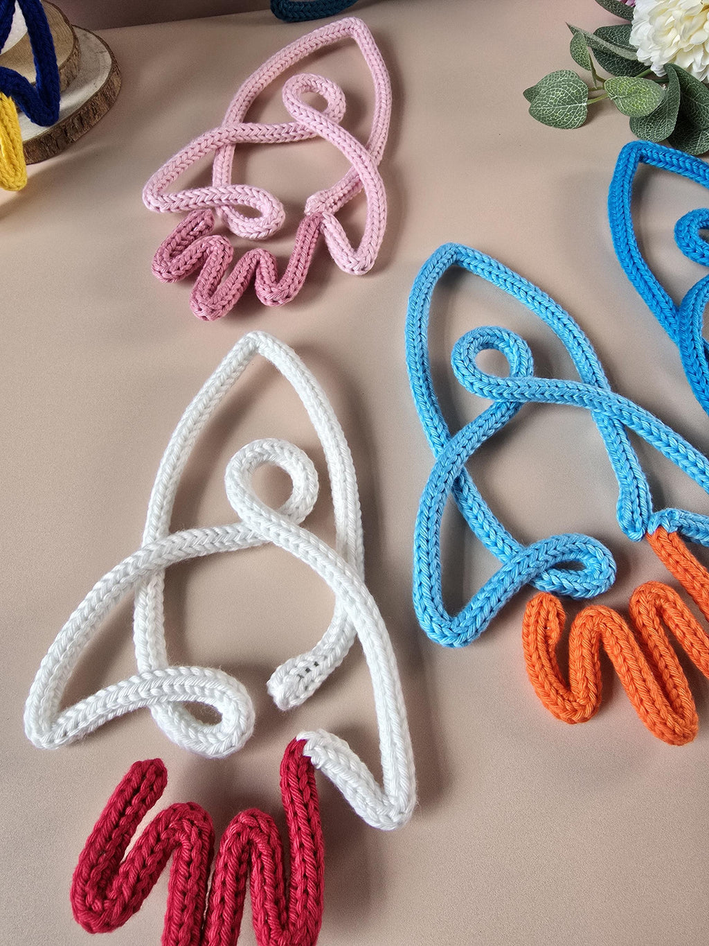 Close-up of handmade knitted wire rocket decoration with cotton yarn texture