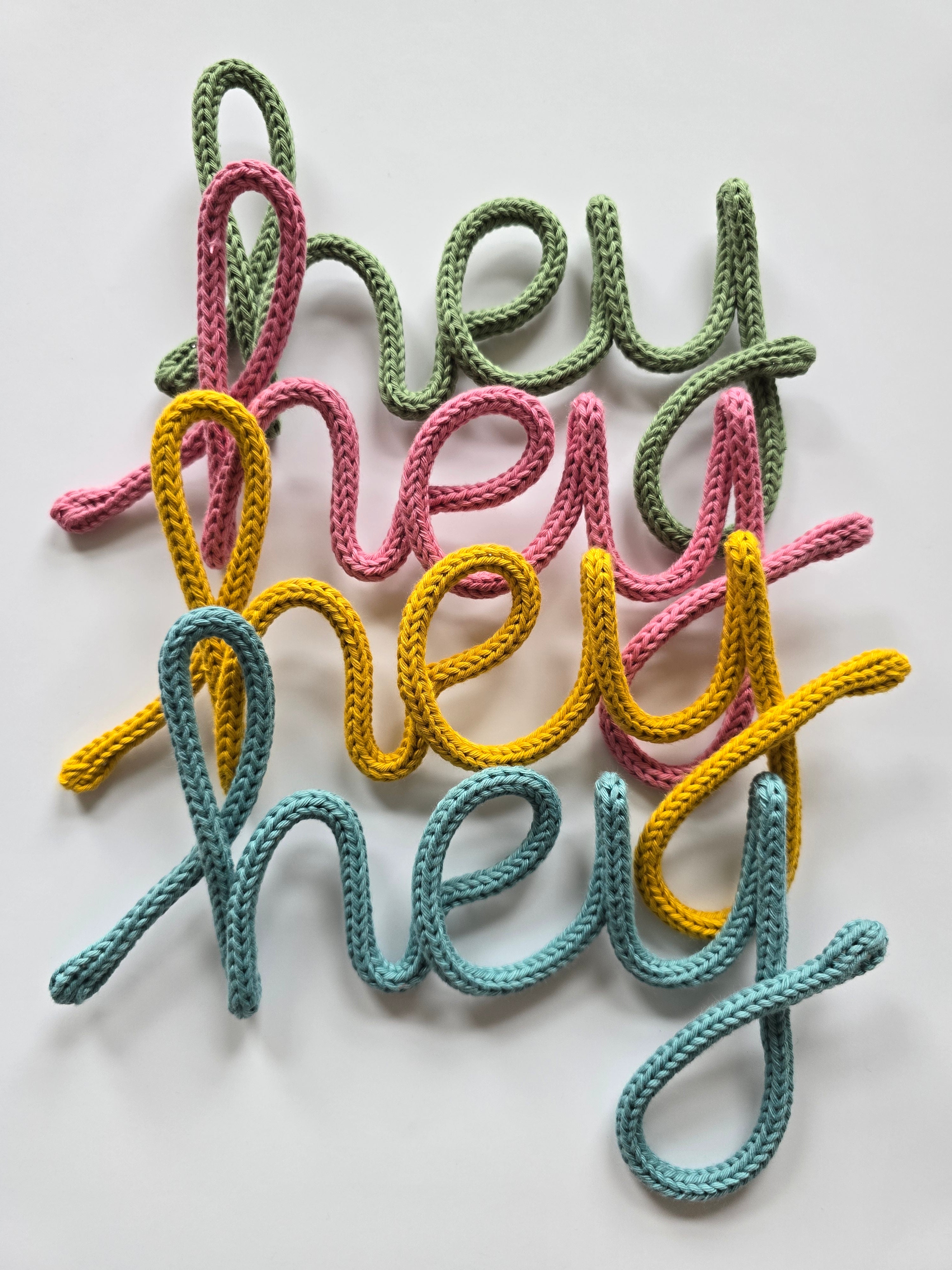 Handmade Hey knitted wire sign in blue, mustard, pink and sage colour