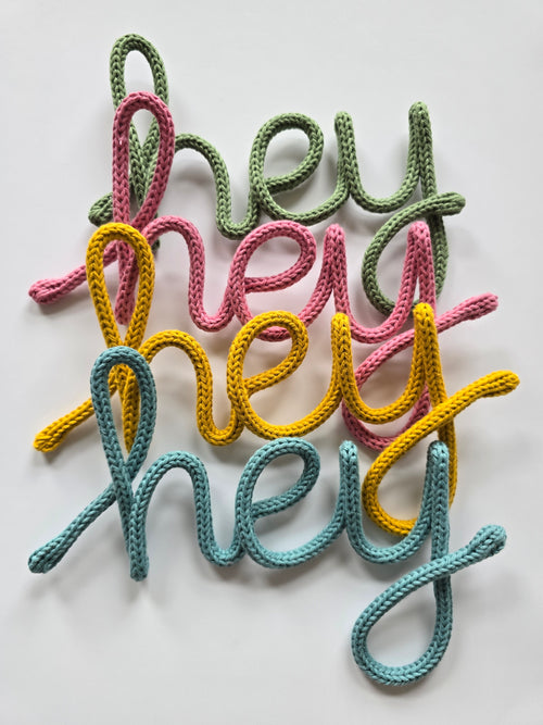Handmade Hey knitted wire sign in blue, mustard, pink and sage colour