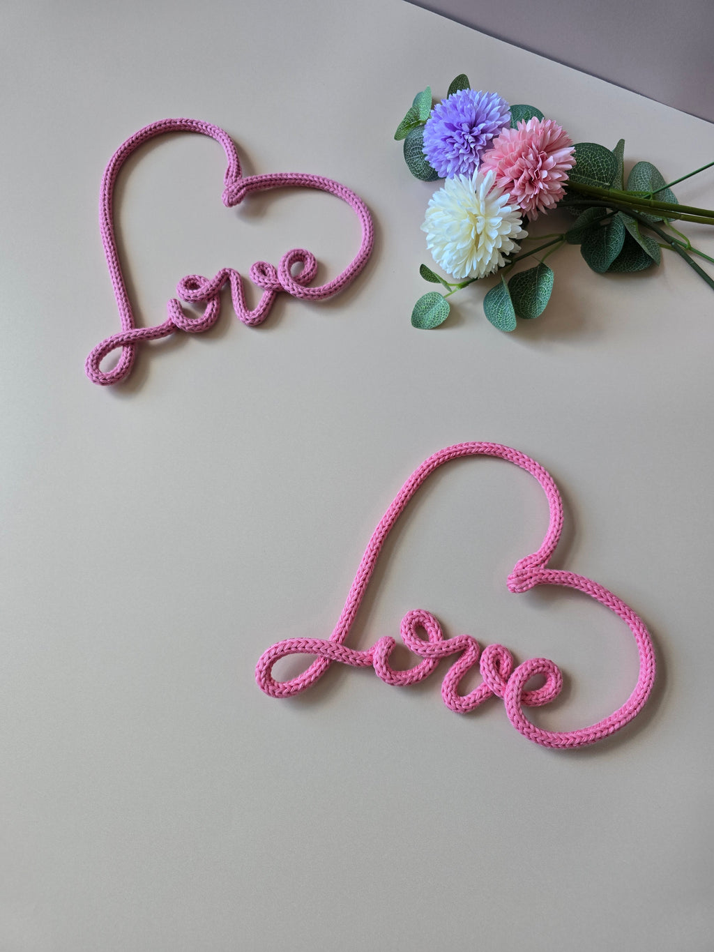 Knitted wire love heart decor shown on a neutral background