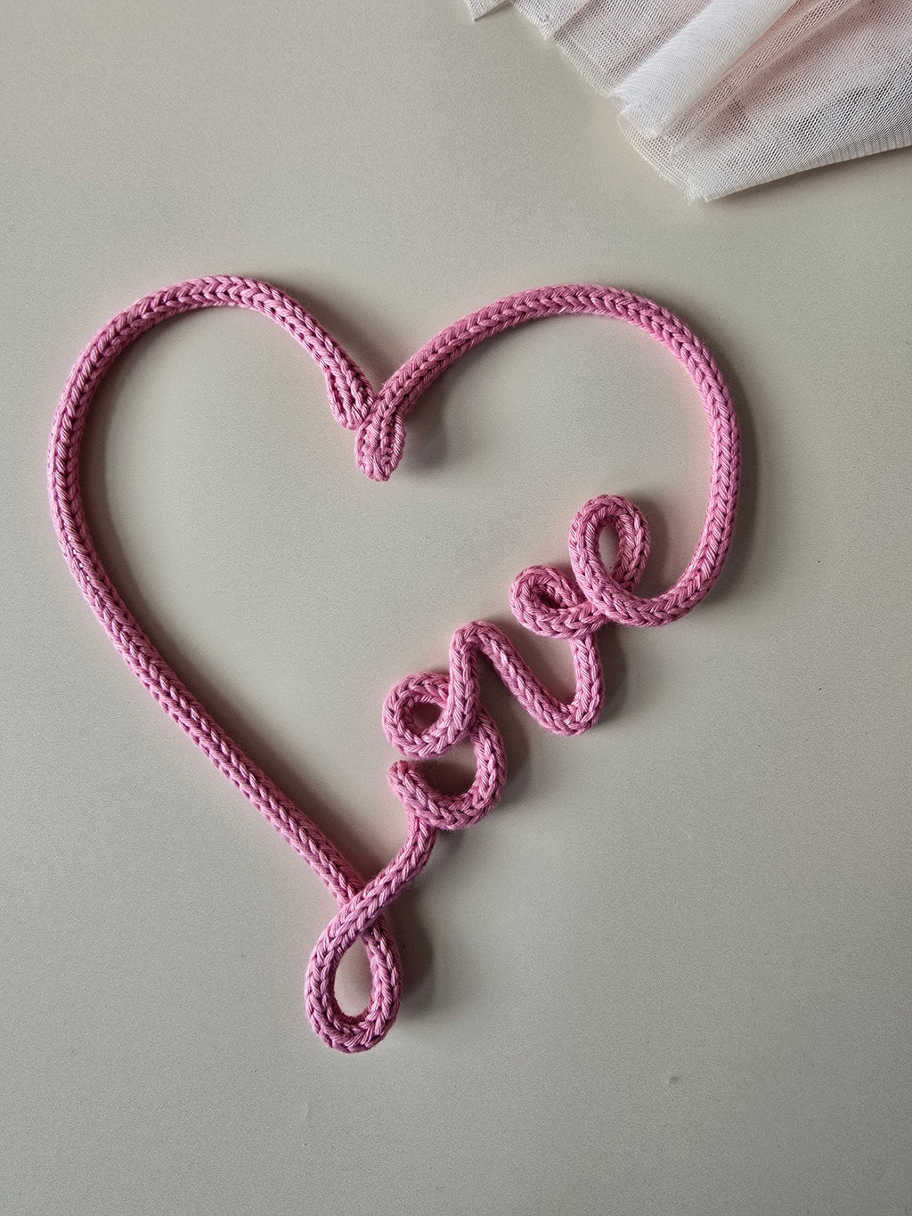 Close-up of handmade knitted wire love heart sign