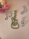 Handmade knitted wire music wall decor showing guitar, treble clef and music note shapes for nursery walls, kids’ bedrooms and music-themed rooms.