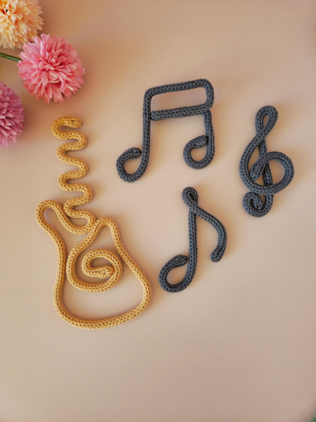 Handmade knitted wire treble clef wall decor in cotton yarn, ideal for music-themed nursery or bedroom decor.