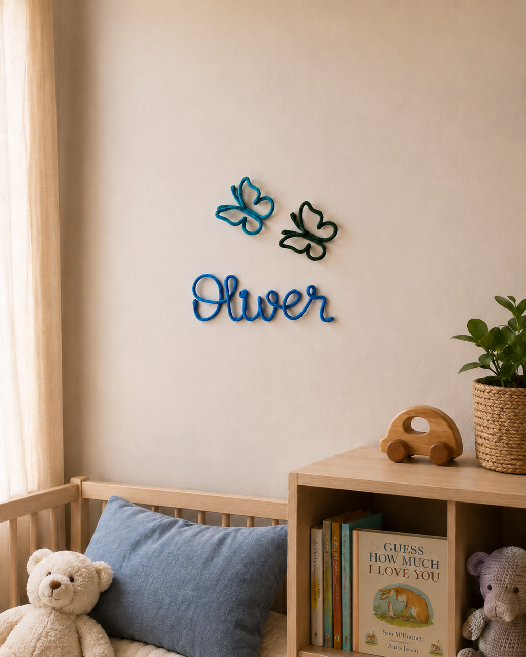 Nursery room with wooden crib, teddy bear, books, and decorative wall letters spelling 'Oliver'.