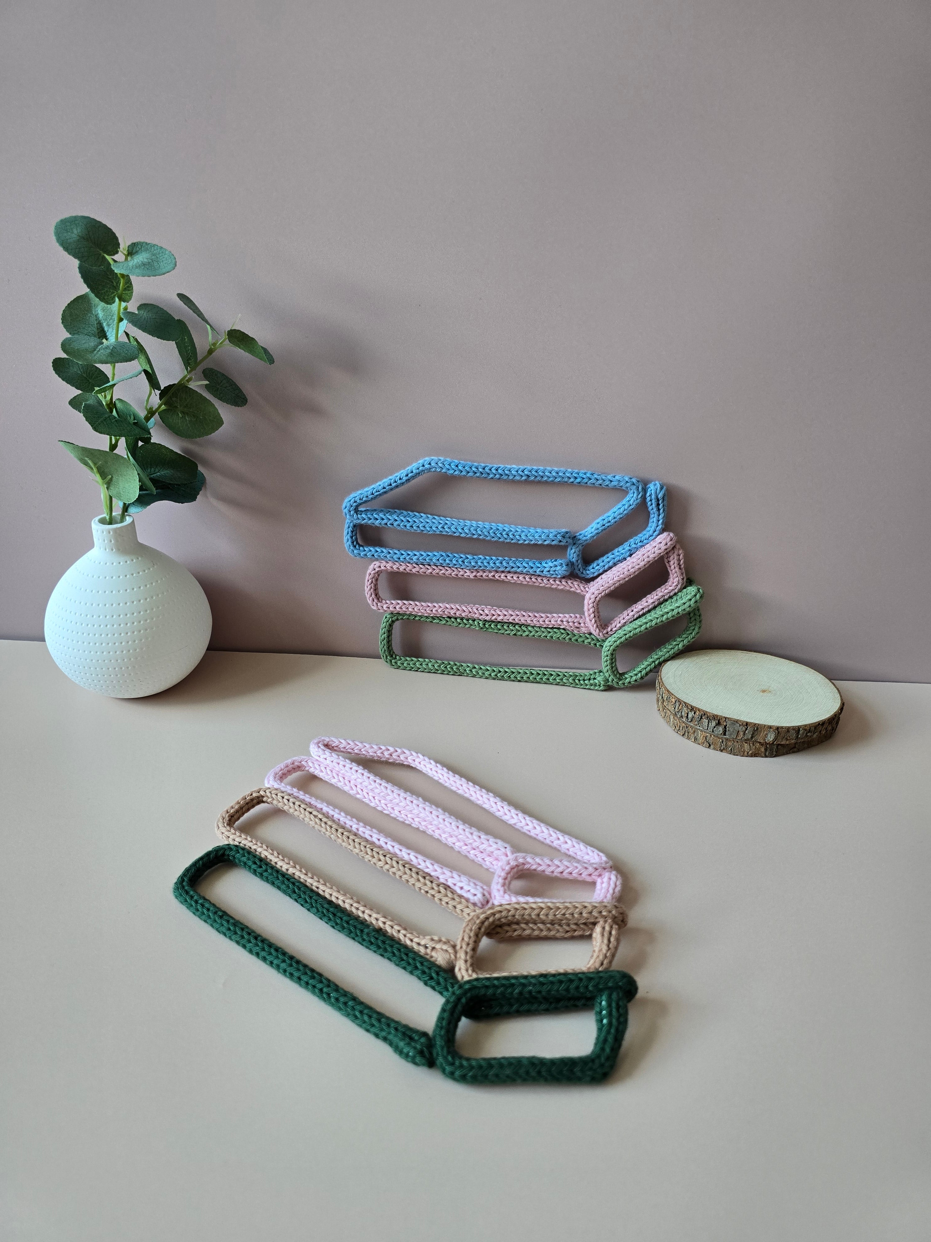 Knitted wire book stack wall decor in pink, beige and dark green