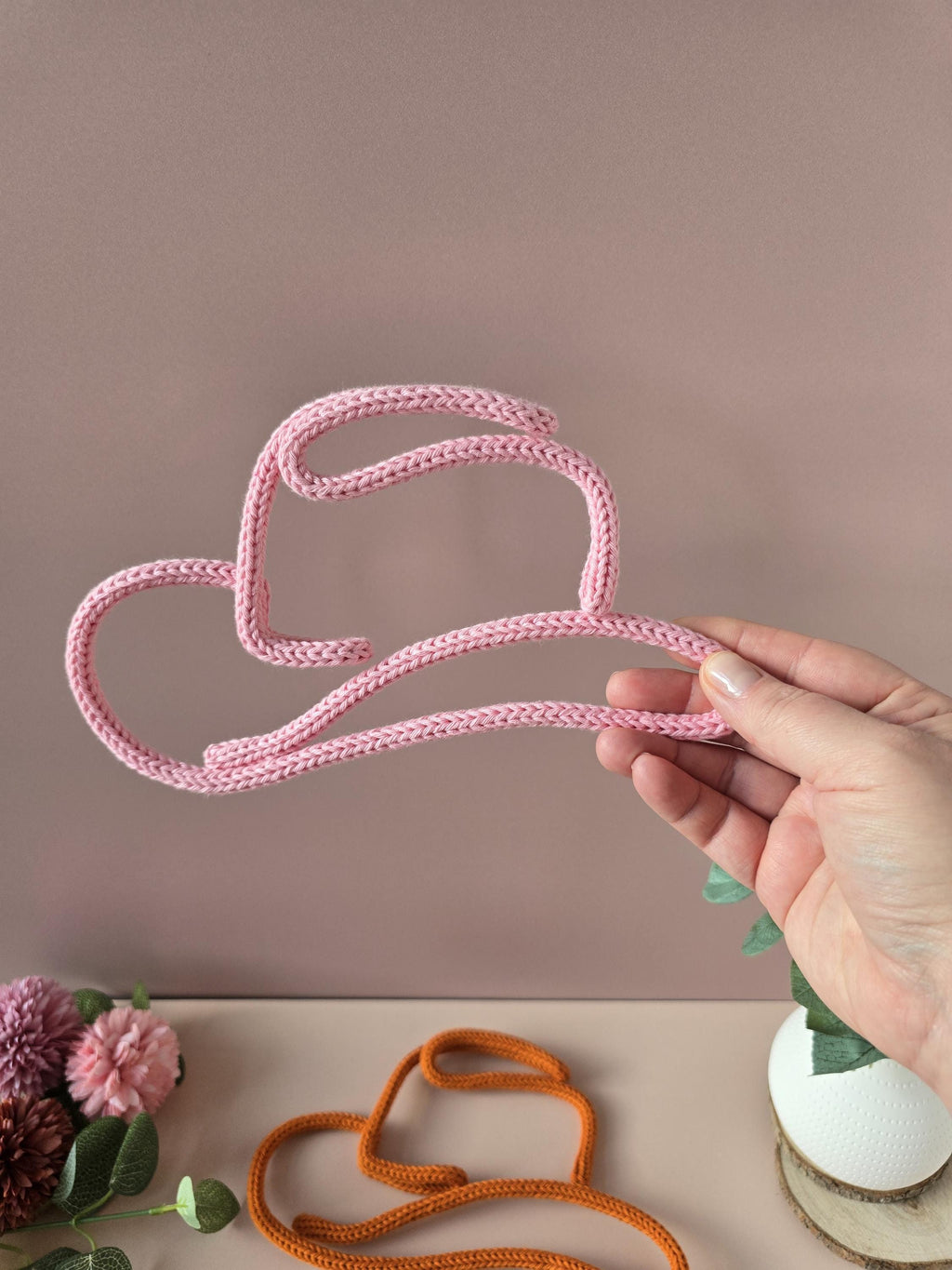 Pink knitted wire cowboy hat and boot decor for a cowgirl room