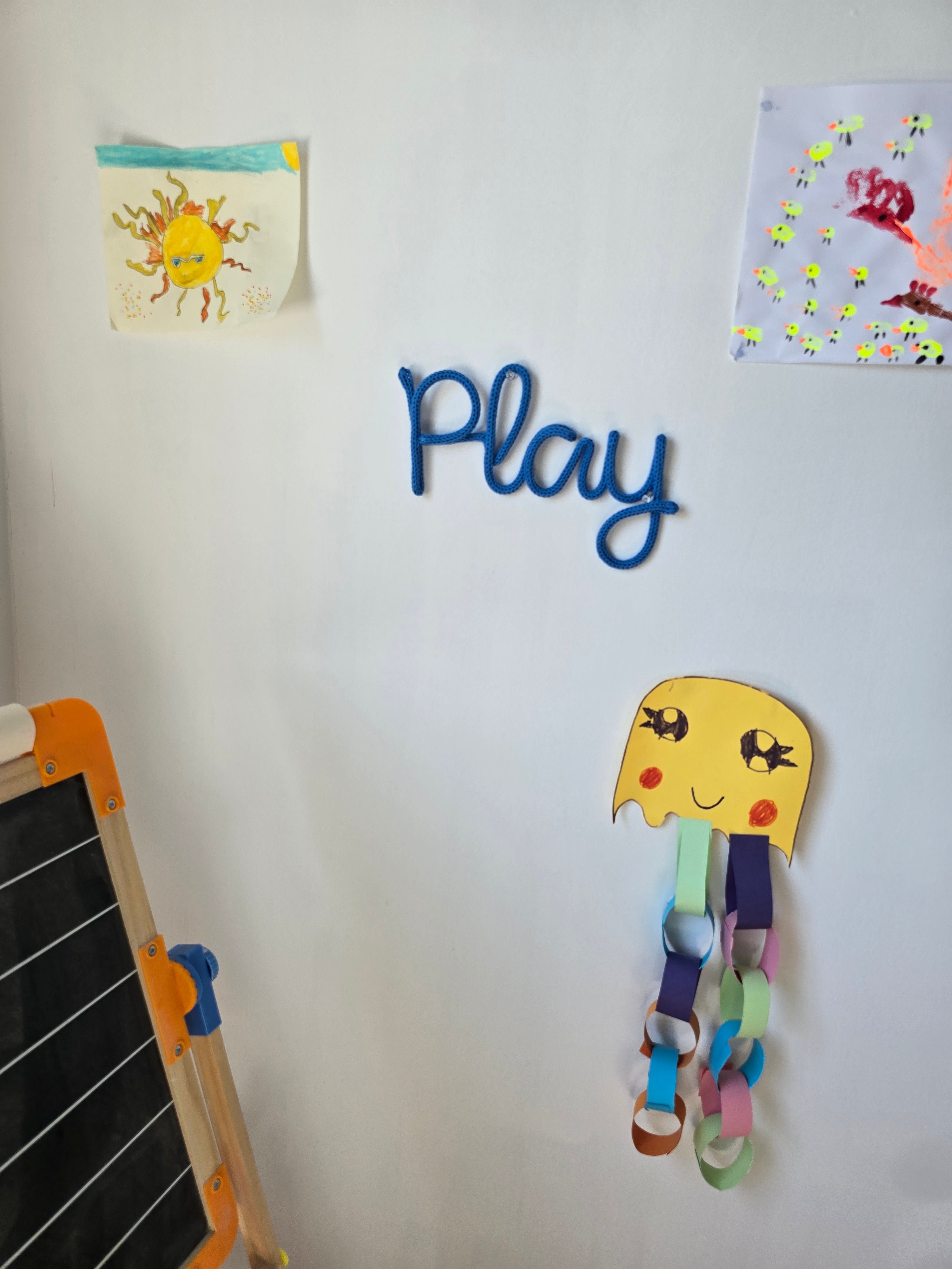 Play knitted wire sign displayed in a child's playroom